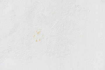 White uneven render stucco concrete wall with cat footprint or paw print stains. Grunge and rough surface. 