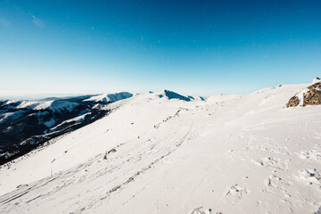 Alpine mountains landscape with white snow and blue sky. Sunset winter in nature. Frosty trees...