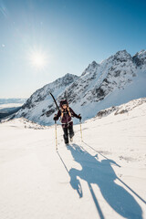 Mountaineer backcountry ski walking ski alpinist in the mountains. Ski touring in alpine landscape with snowy trees. Adventure winter sport. High tatras, Slovakia