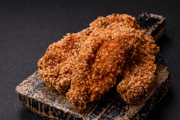 Delicious fresh crispy chicken nuggets on a dark concrete background