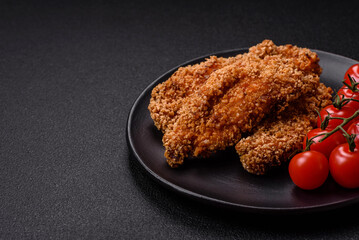 Delicious fresh crispy chicken nuggets on a dark concrete background