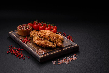 Delicious fresh crispy chicken nuggets on a dark concrete background