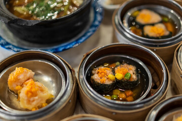 dim sum variety to many with shrimp eggs and bak kut teh soup in bowl and small wooden basket for...