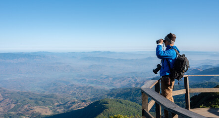 Hiker with backpacks and cameras are using binoculars to take in the views from the high peaks