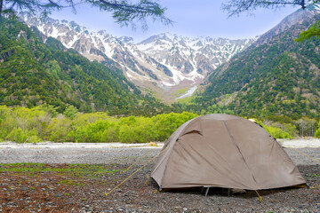 Camping tent outdoor. Camping leisure and destination travel near green forest mountain snow winter...