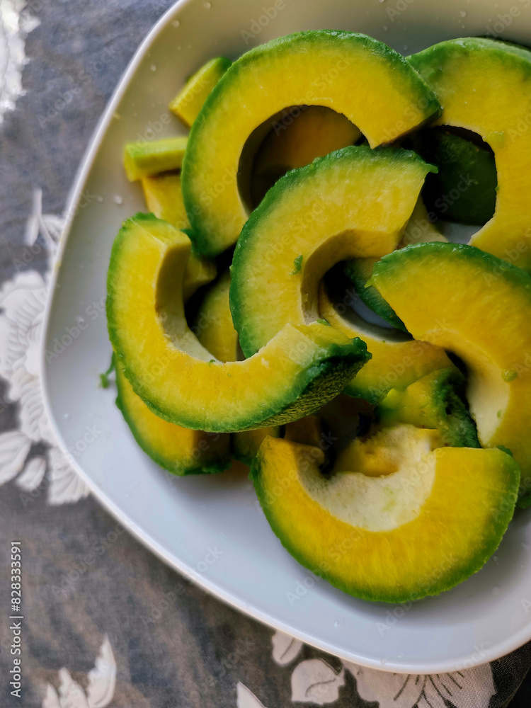 Wall mural a bowl of fresh avocado slices. avocados have many benefits such as maintaining heart and eye health