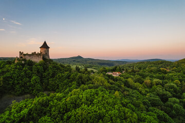 Fototapeta premium Ruins of a medieval castle Somoska or Somoskoi var on borders of southern Slovakia and Hungary at sunrise time. .Salgo Castle or Salgo vara in background