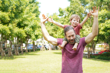 Happy Family.  Happy little boy stretching out hands while his father carrying him cheerful and...