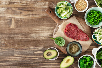 Fresh raw ingredients to preparation a healthy plate on wooden background, beef tenderloin, bulgur...