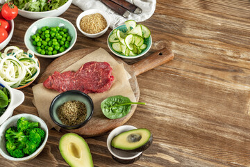 Set of raw ingredients to cooking a healthy plate on wooden table, beef tenderloin, bulgur grains and various vegetables top view, diet food