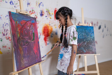 Schoolgirl paint on canvas show creative idea in drawing class. Kid paint canvas all around use...