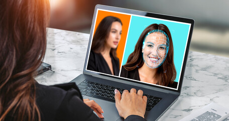 Businesswoman using laptop with biometric scanning hologram, face swapping