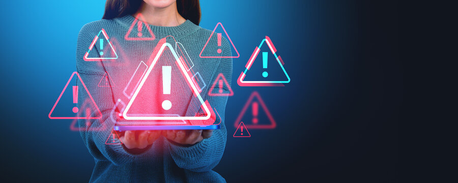 Woman holding a tablet with floating warning symbols, digital ar