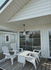 Farmhouse outdoor terrace or porch. Modern exterior design concept with chairs and table. Elegant...