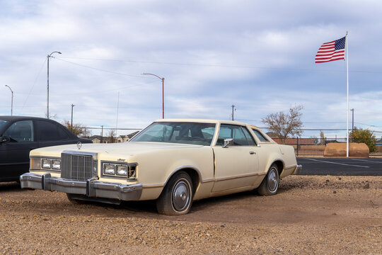 Winslow, AZ 86047, USA - 5 November 2022. Beige Mercury Cougar XR7 1979 in the parking lot with american flag