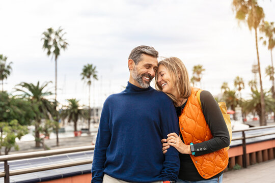 Romantic portrait of adult couple bonding with love in the city
