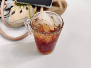 A glass of iced tea. A nice cool drink to enjoy on a hot day. White background and some blurred items.