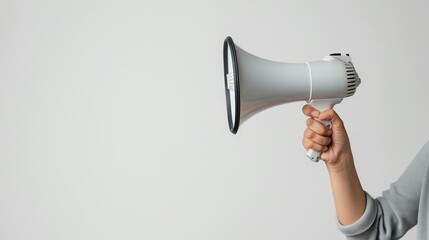 A hand holding a white megaphone on a white background. Copy space.