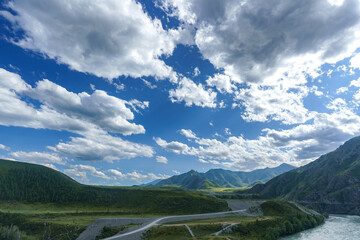 panorama of the landscape, Altai, pass, mountain slopes, valley, bends of the road, white clouds in...