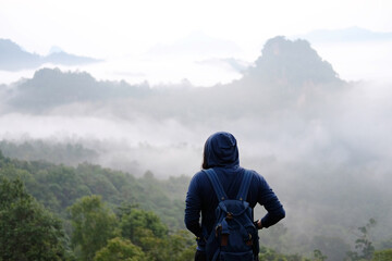 Asian woman freedom journey with valley mountain and foggy in natural and travel destination in tropical rain forest