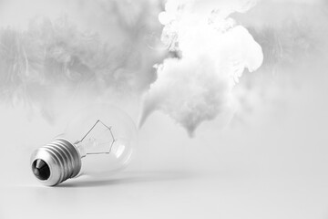 Incandescent light bulb and smoke on a white background, light