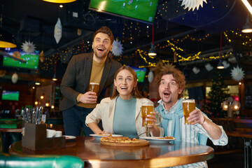 Excited friends crazy screaming supporting soccer team watching match at sports bar