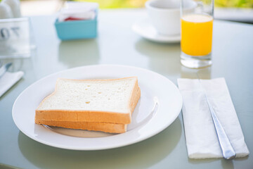 White bread slices with orange juice on breakfast table