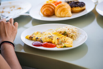 Breakfast plate with omelette, ketchup, and noodles