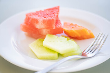 Plate of assorted melon slices with fork