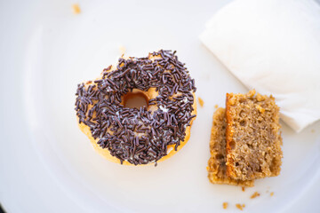 Donut with chocolate sprinkles and cake on a plate