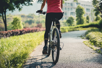 Fototapeta premium Woman riding mountain biking in sunny park