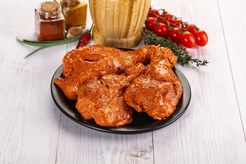 Raw turkey shoulder wing in Indian tandoori marinade