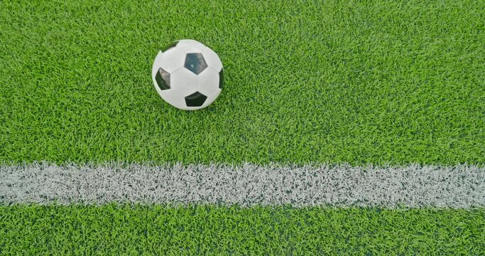 Soccer field impressions  - A passed soccer ball slowly rolls from the left to the right side, parallel to one of the soccer field's marking lines