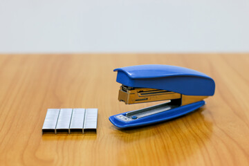 Photo of Blue stapler put on the table in office with a blurred background, stapler is a device...