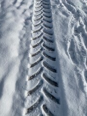 Spur im Schnee von Traktor, Fahrspur von Auto - Reifen im Winter
