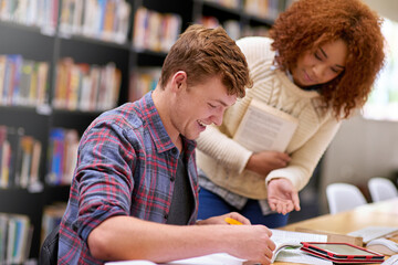 Student, notebook and help in library for study, education and university certificate with quiz on table. Man, support and book on school for college diploma, research and learning with scholarship