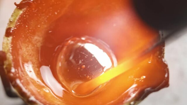 Heating with a flame jet of a metal billet of a silver ring. The work of a jeweler in the workshop