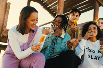 Happy friends enjoying summer holiday with ice pops outdoors © Jacob Lund
