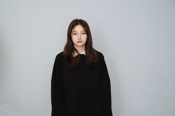 Fototapeta premium Serious young woman in a black hoodie, a neutral expression on her face, ideal for brand mockups and fashion templates.