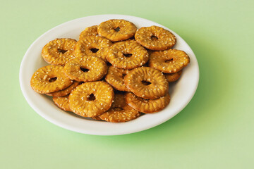 Round crackers with a hole and salt on a light green background