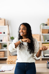 Indian woman talking on smart watch in the office. Young entrepreneur sending home automation message.