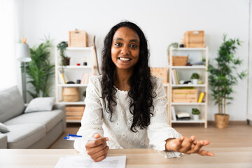 Young Indian woman talking to camera at home. Webcam view of student having video call.