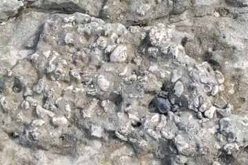 Beachrock is a friable to well-cemented sedimentary rock that consists of a variable mixture of basalt gravel , sand , and silt-sized sediment. fragments of coral and shells . Geology 