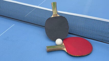 Rackets and ball on a blue tennis table - equipment for table tennis or ping pong. Old and new...