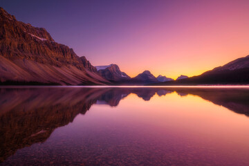 Obraz premium Mountain landscape at dawn. Sunbeams in a valley. Lake and high peaks in a mountain valley at dawn.