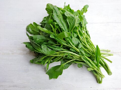 Raw green living cress or watercress leaves bunch on wooden table background. Organic healthy leaves of cress for eat. Garden cress or watercress (Lepidium sativum) mustard garden pepper pepperwort