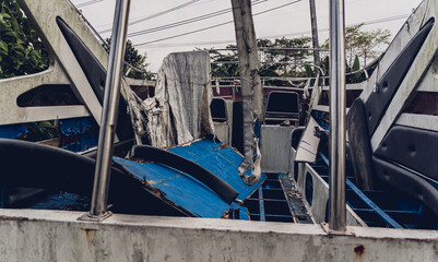 Old and rusty motor boats on a landfill surrounded by tropical forest