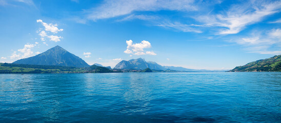 lake Thunersee and Niesen mountain, view from boat trip, blue sky with clouds. switzerland