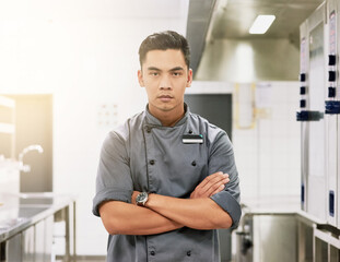 Asian man, portrait and chef with arms crossed in kitchen for professional cooking, hospitality or...