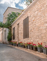 Pano Lefkara village, Larnaka region, Cyprus-May 24, 2024: Stone houses, white walls, narrow cobbled lanes, doors, windows, flowers, flowerpots, billboards, as seen in the village narrow streets 